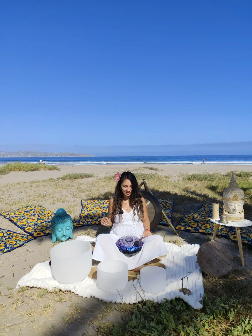 Bárbara tocando el handpan durante un baño de sonido en la playa